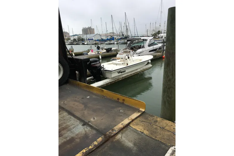 Slide: The Image of 2016 Mako 18 LTS boat docked at a marina with other vessels. - 8