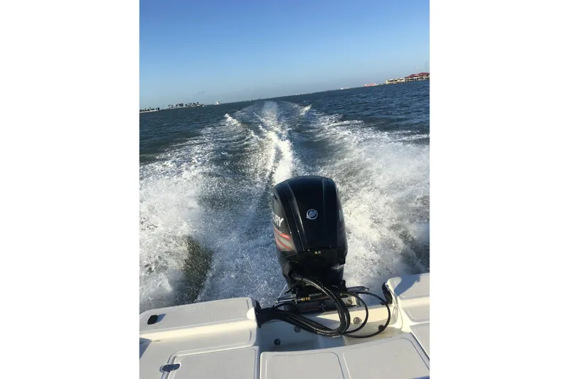 Slide: The Image of 2016 Mako 18 LTS boat cruising on open water, rear view. - 9