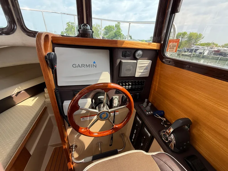 Slide: The Image of 2017 Ranger Tugs R-27 helm with Garmin navigation system and wooden steering wheel. - 10