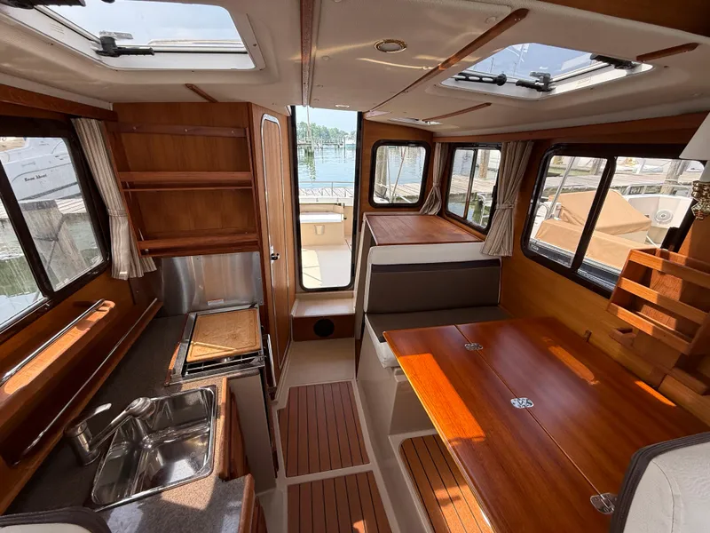 Slide: The Image of Interior of 2017 Ranger Tugs R-27 boat with wood finish and ample natural light. - 13