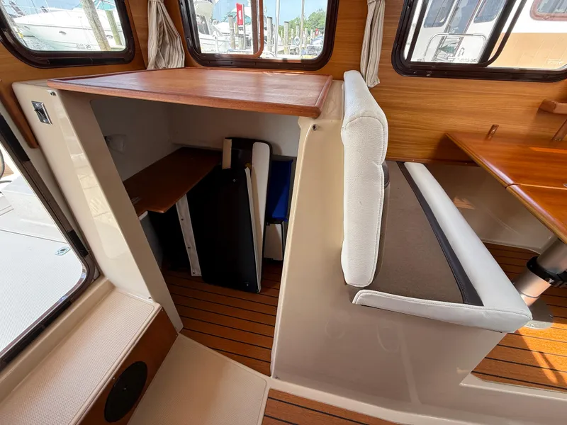 Slide: The Image of Interior of a 2017 Ranger Tugs R-27 boat with seating and wooden surfaces. - 15
