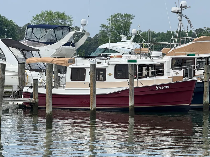 Slide: The Image of 2017 Ranger Tugs R-27 boat docked at marina, surrounded by other vessels. - 2
