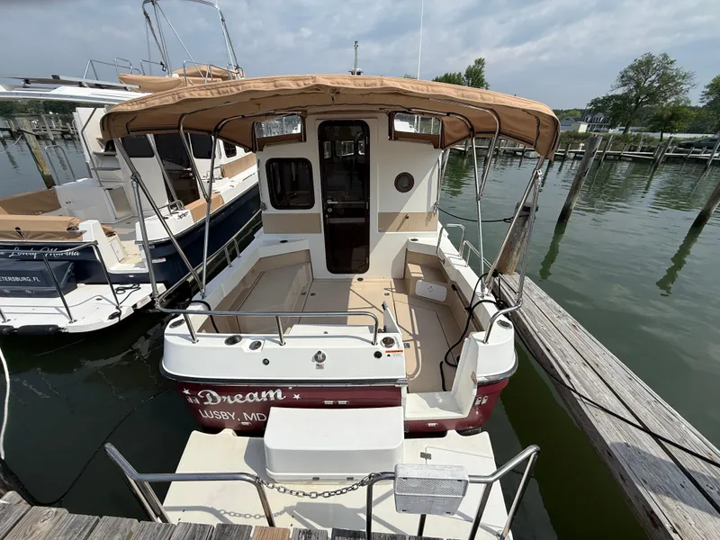 Slide: The Image of 2017 Ranger Tugs R-27 boat docked, featuring a spacious deck and canopy. - 3