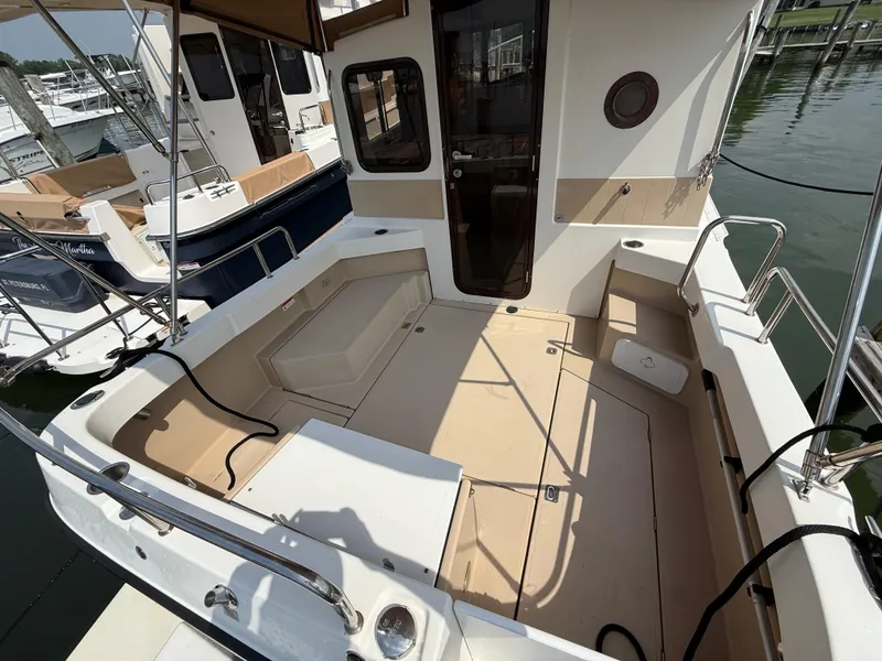 Slide: The Image of 2017 Ranger Tugs R-27 boat deck with seating, docked at marina. - 5
