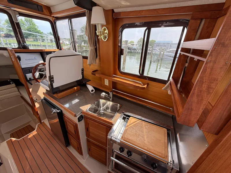 Slide: The Image of Interior of 2017 Ranger Tugs R-27 boat with kitchen and steering area. - 8