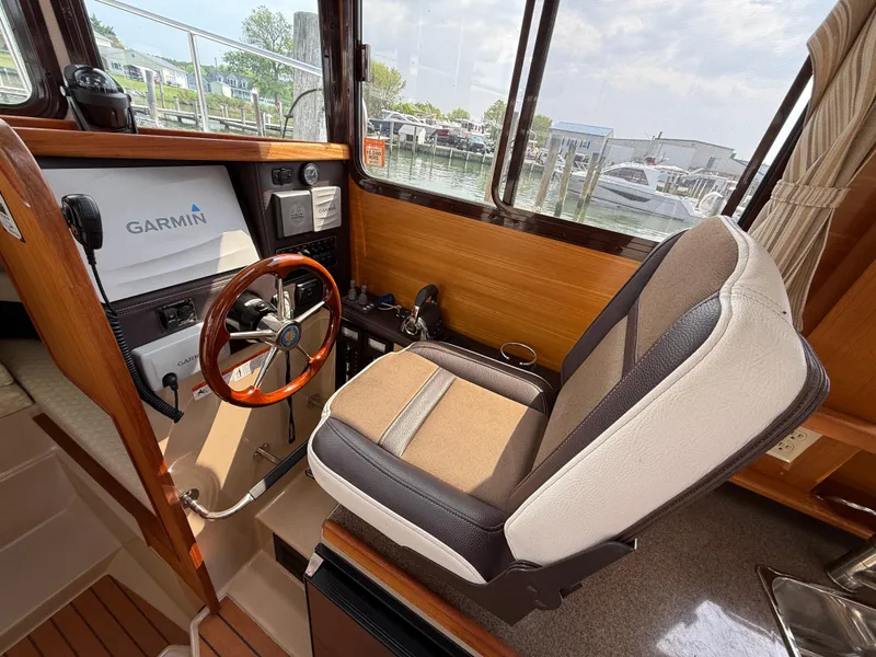 Slide: The Image of 2017 Ranger Tugs R-27 helm with Garmin navigation, featuring a comfortable captain's chair. - 9