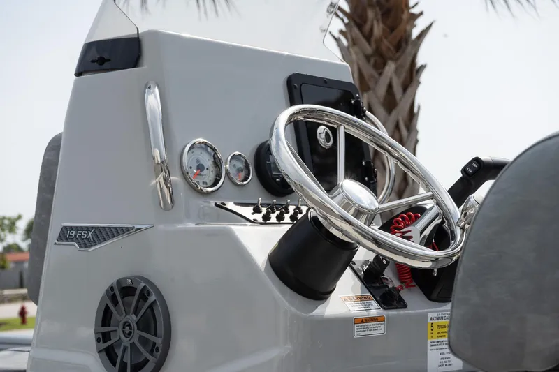 Slide: The Image of 2025 Avid 19 FSX boat dashboard with steering wheel and gauges. - 13