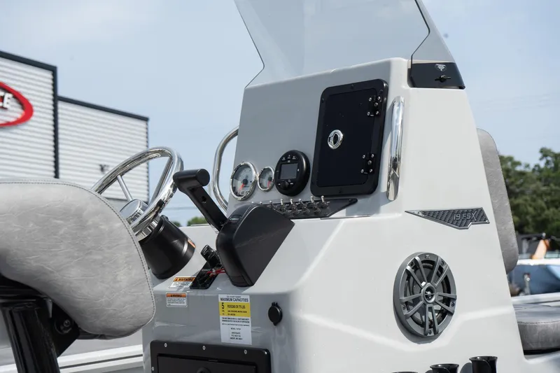 Slide: The Image of 2025 Avid 19 FSX boat console with steering wheel, gauges, and speaker. - 15