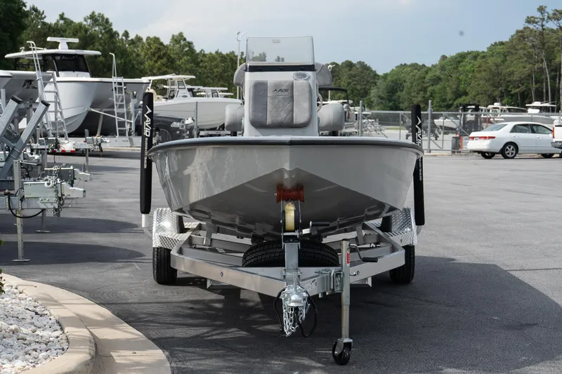Slide: The Image of 2025 Avid 19 FSX boat on trailer in parking lot, surrounded by trees and other boats. - 4