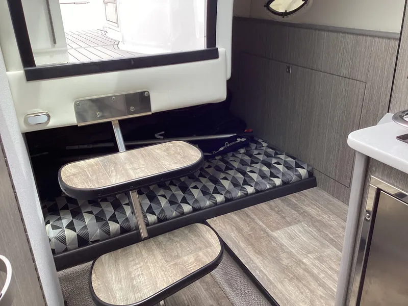 Slide: The Image of Interior of 2022 Monterey 295 Sport Yacht with modern wood finish and geometric-patterned seating. - 13