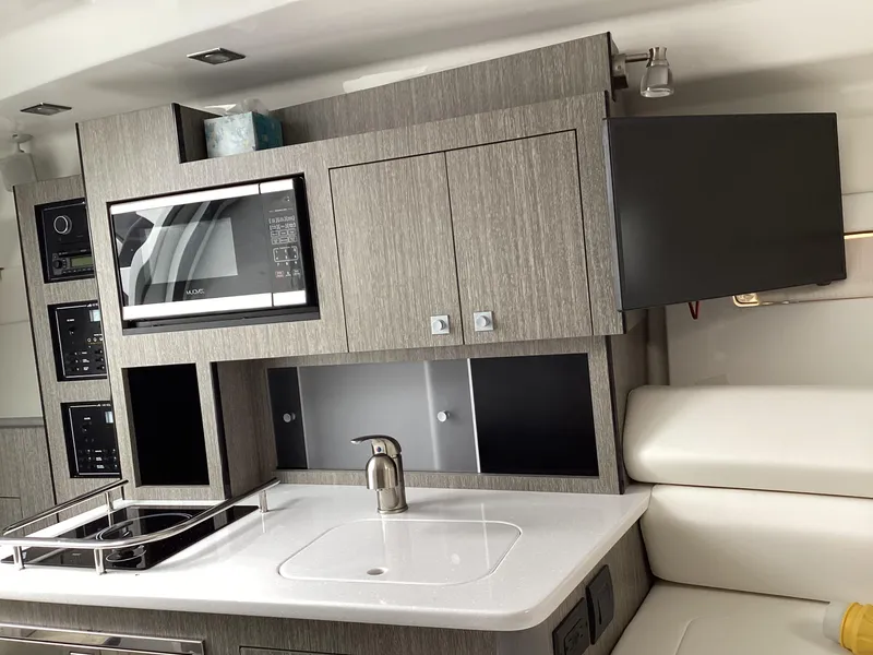 Slide: The Image of Modern kitchen interior of 2022 Monterey 295 Sport Yacht with microwave and sink. - 16