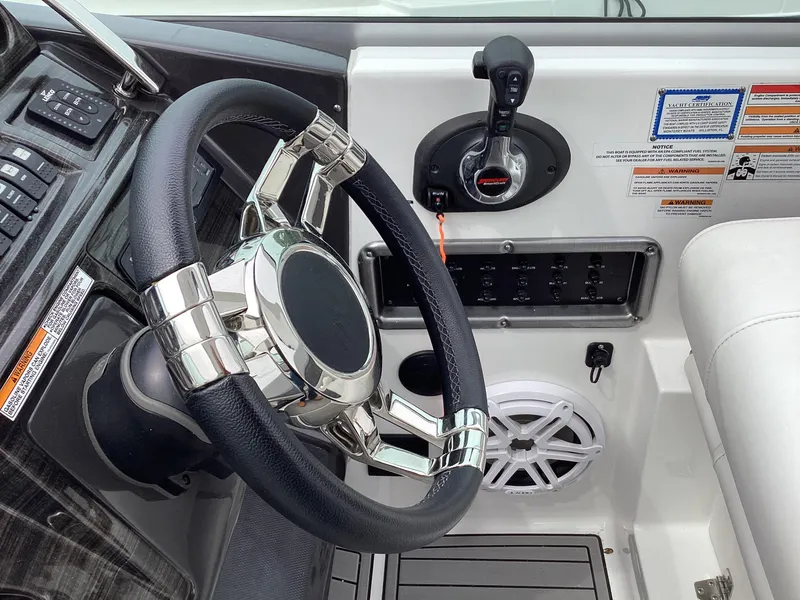 Slide: The Image of 2022 Monterey 295 Sport Yacht helm with steering wheel and control panel. - 20