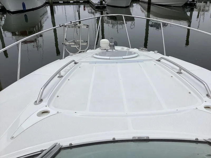 Slide: The Image of 2022 Monterey 295 Sport Yacht bow view at marina, showcasing sleek design and railing. - 21