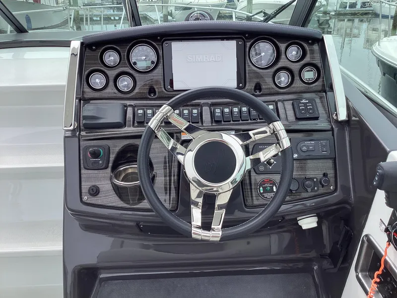 Slide: The Image of 2022 Monterey 295 Sport Yacht dashboard with modern controls and sleek steering wheel. - 22
