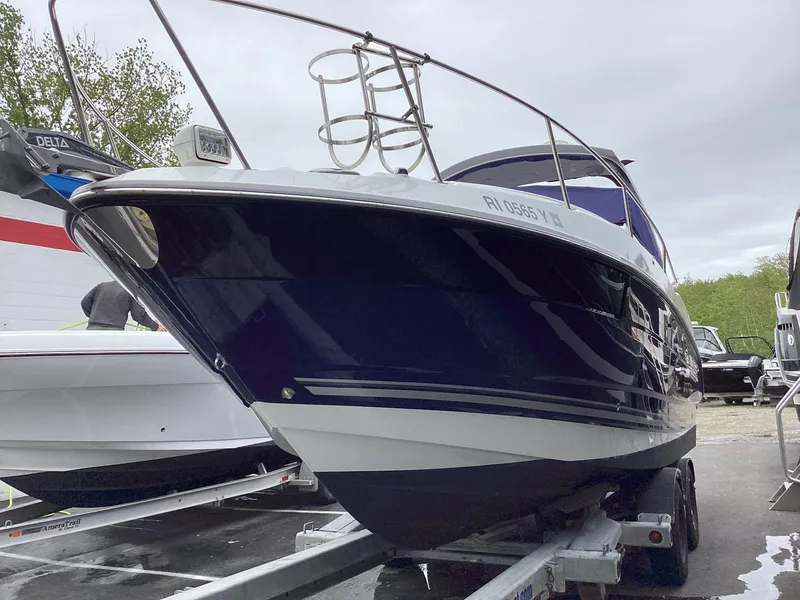 Slide: The Image of 2022 Monterey 295 Sport Yacht on trailer, sleek design, parked outdoors. - 23