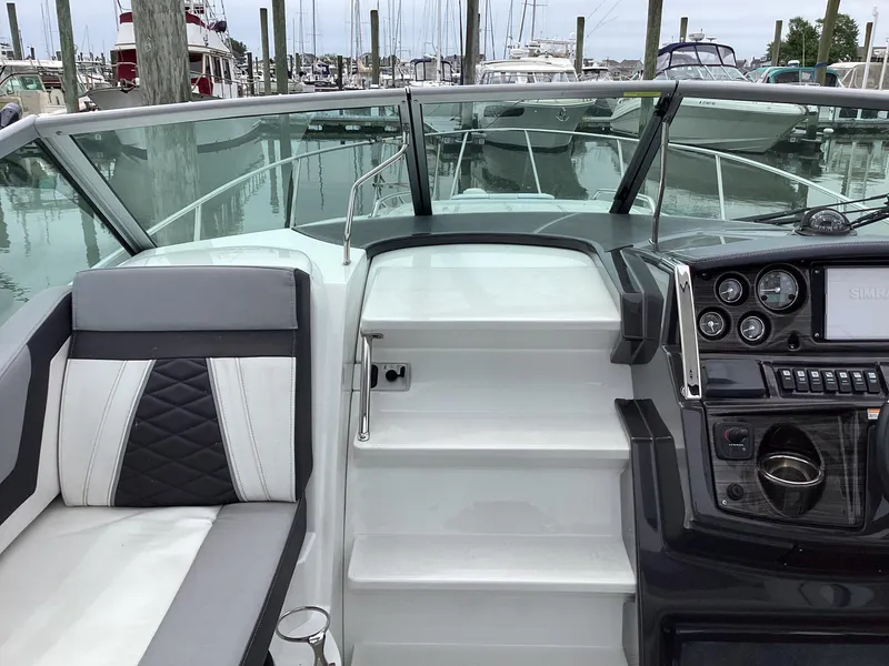 Slide: The Image of 2022 Monterey 295 Sport Yacht cockpit with modern dashboard and seating at marina. - 27