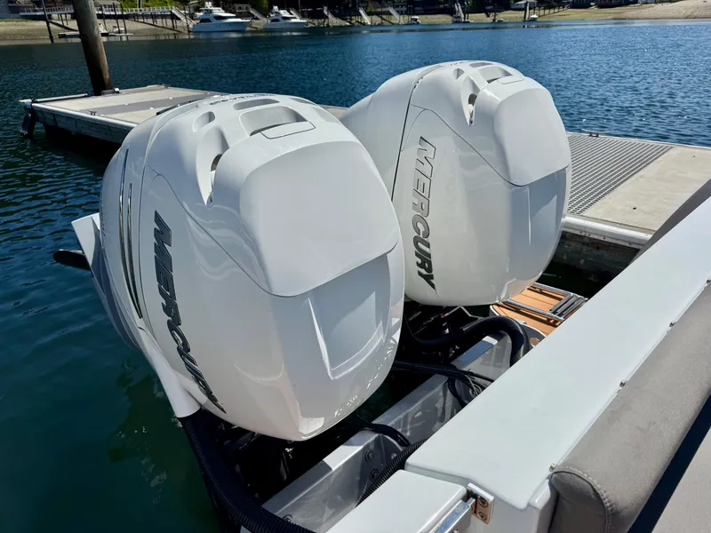 Slide: The Image of Twin Mercury outboard engines on a 2020 Coastal Craft 33 Express boat at a dock. - 12