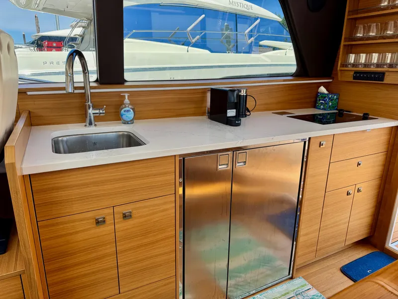 Slide: The Image of Modern kitchen interior of 2020 Coastal Craft 33 Express yacht with wood cabinetry and stainless steel appliances. - 16