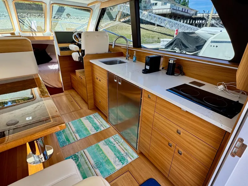 Slide: The Image of Interior of 2020 Coastal Craft 33 Express yacht with modern kitchen and seating area. - 22