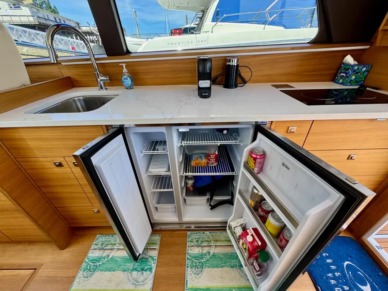 Slide: The Image of Modern kitchen in 2020 Coastal Craft 33 Express yacht with open fridge and sleek countertops. - 26