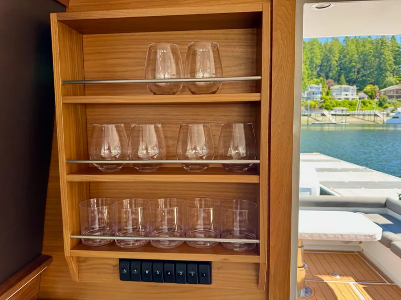 Slide: The Image of Glassware shelf on 2020 Coastal Craft 33 Express yacht, overlooking serene waterfront. - 27