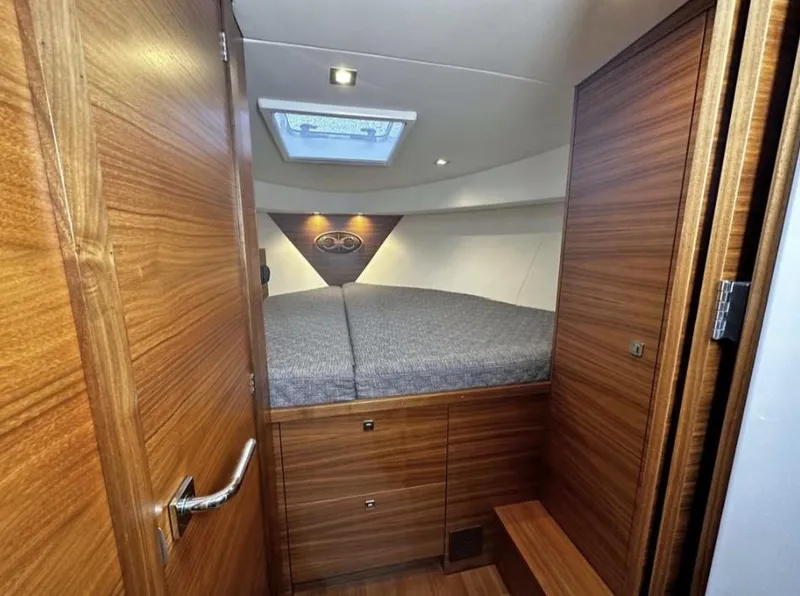 Slide: The Image of 2020 Coastal Craft 33 Express cabin interior with wood finish and skylight. - 28