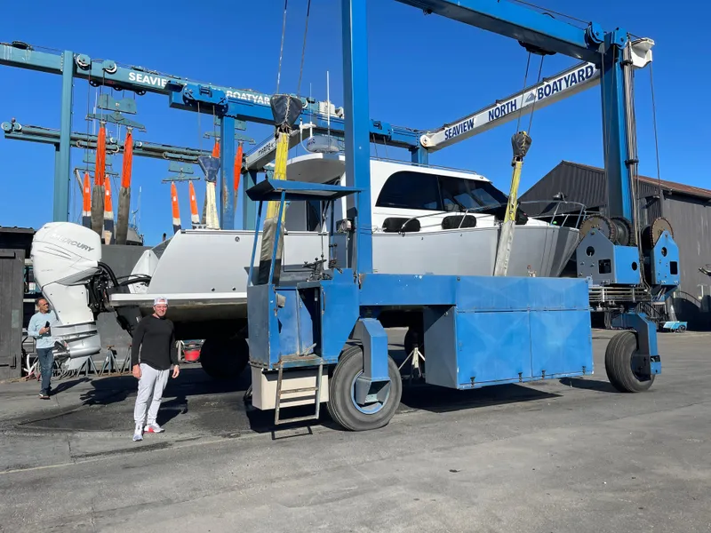 Slide: The Image of 2020 Coastal Craft 33 Express yacht in boatyard lift, clear blue sky background. - 4