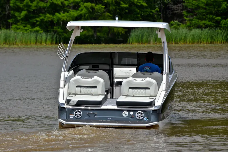 Slide: The Image of 2022 Regal LS4 boat cruising on a calm lake with lush green background. - 10