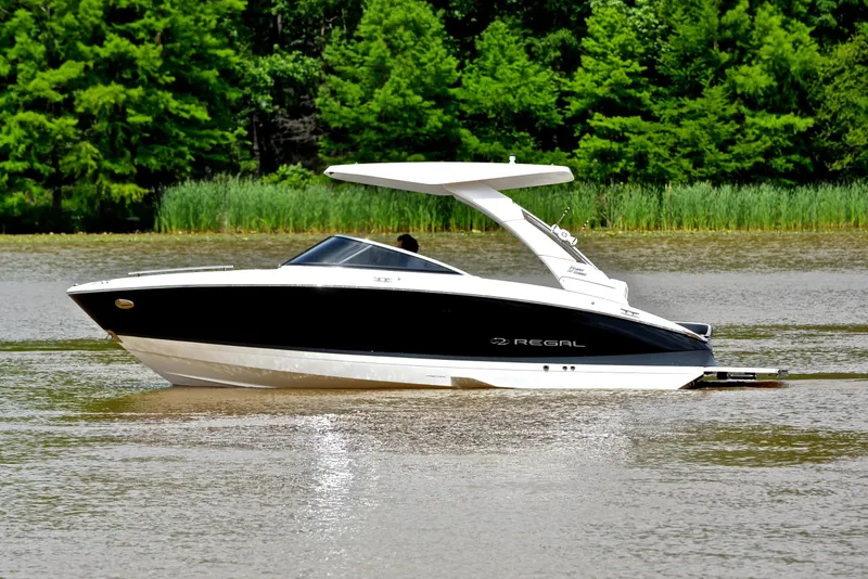 Slide: The Image of 2022 Regal LS4 boat cruising on a calm lake with lush green trees in the background. - 11