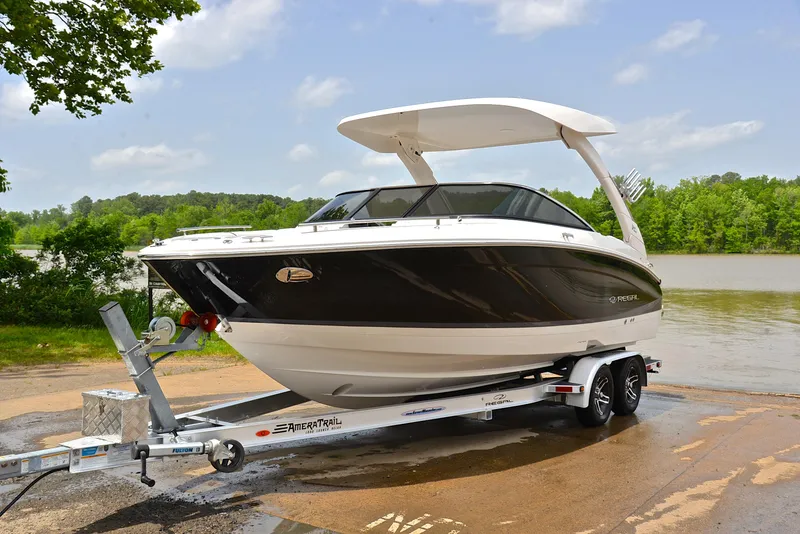 Slide: The Image of 2022 Regal LS4 boat on trailer by a lake, ready for launch. - 13