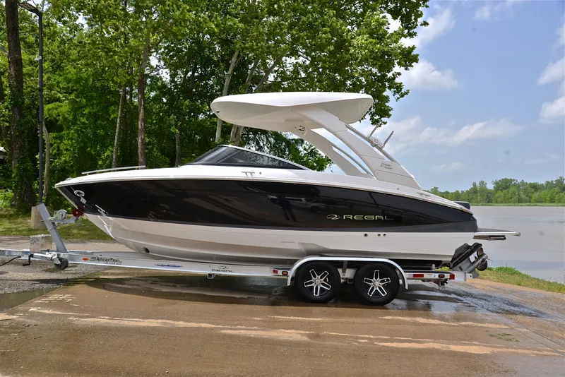 Slide: The Image of 2022 Regal LS4 boat on trailer by a lake, surrounded by trees. - 14