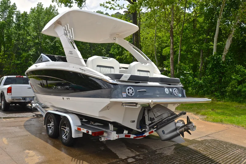 Slide: The Image of 2022 Regal LS4 boat on trailer, parked outdoors near trees. - 15