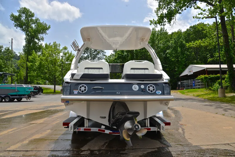 Slide: The Image of 2022 Regal LS4 boat on trailer, rear view, parked outdoors with trees in background. - 16