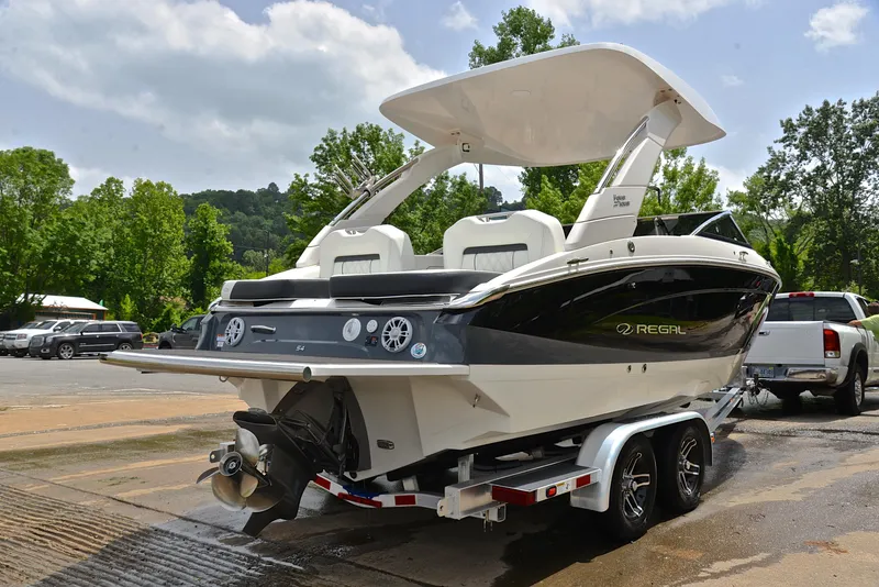 Slide: The Image of 2022 Regal LS4 boat on trailer, parked outdoors with lush greenery background. - 17