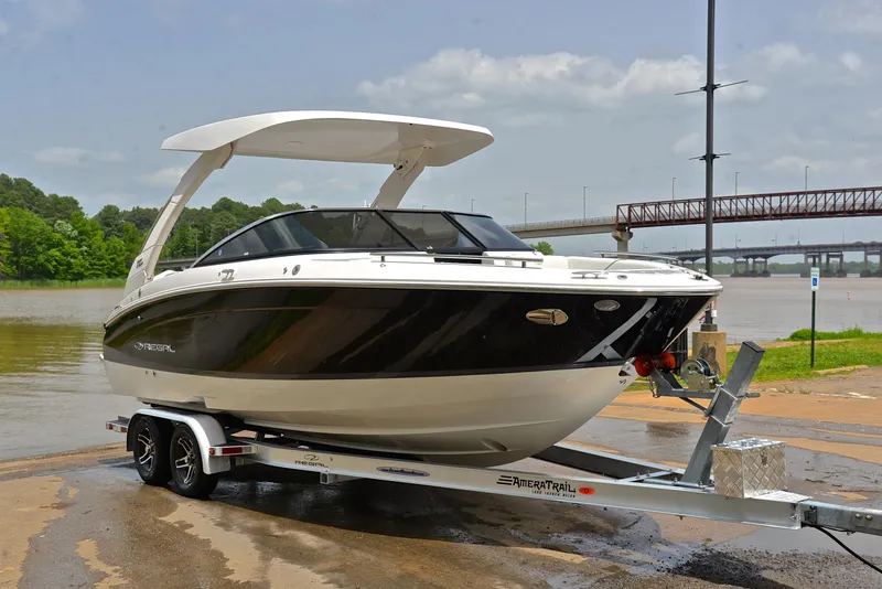 Slide: The Image of 2022 Regal LS4 boat on trailer by riverside, under cloudy sky. - 19