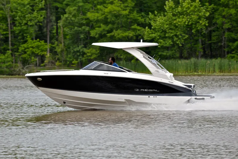 Slide: The Image of 2022 Regal LS4 boat cruising on a lake with lush green trees in the background. - 3