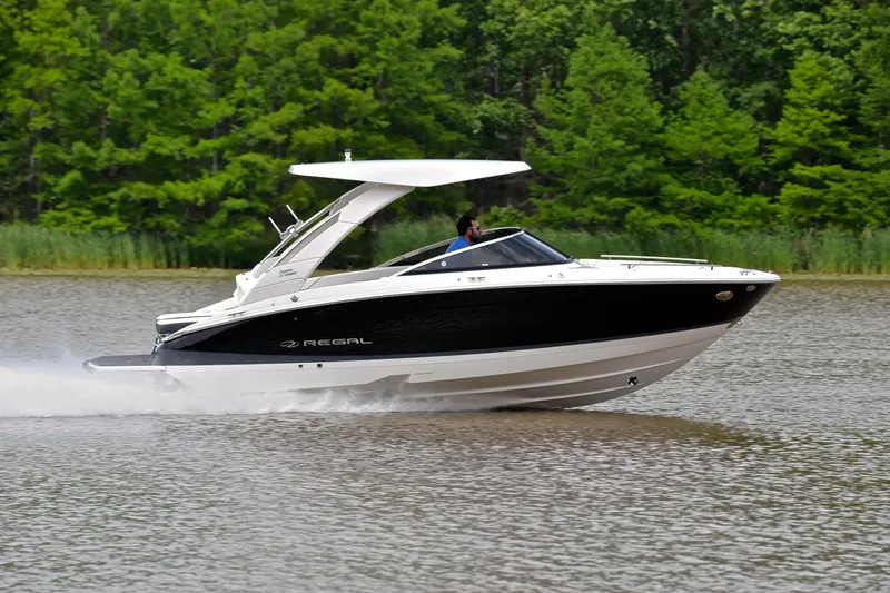 Slide: The Image of 2022 Regal LS4 boat cruising on a lake with lush green trees in the background. - 4