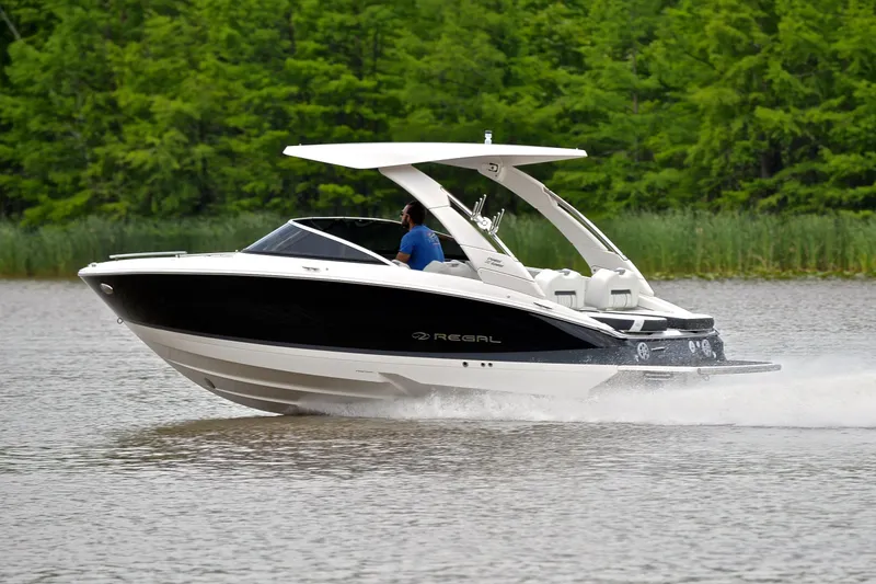Slide: The Image of 2022 Regal LS4 boat cruising on a lake with lush green trees in the background. - 5