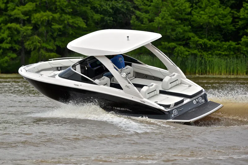 Slide: The Image of 2022 Regal LS4 boat cruising on a lake with lush green trees in the background. - 7