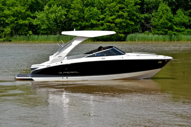 Slide: The Image of 2022 Regal LS4 boat cruising on a calm lake with lush green trees in the background. - 9