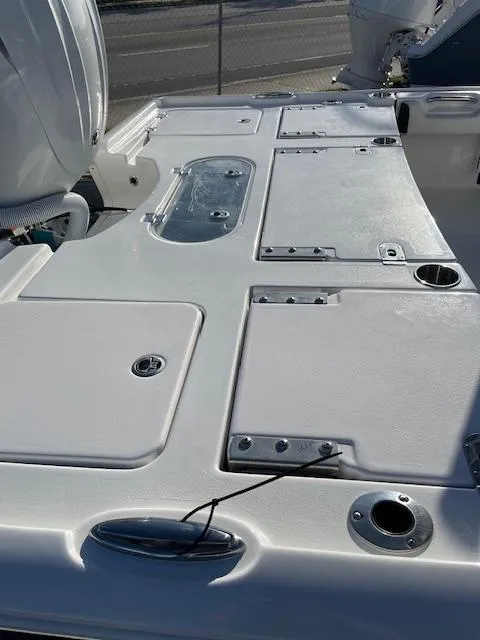 Slide: The Image of 2025 Tidewater 2500 Carolina Bay boat deck with storage compartments and rod holders. - 13
