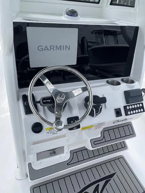 Slide: The Image of 2025 Tidewater 2500 Carolina Bay boat console with Garmin display and steering wheel. - 16