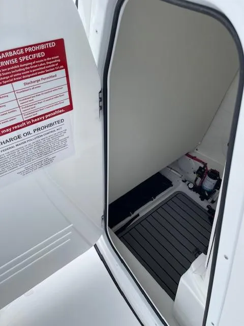 Slide: The Image of 2025 Tidewater 2500 Carolina Bay boat interior storage compartment with safety instructions. - 23