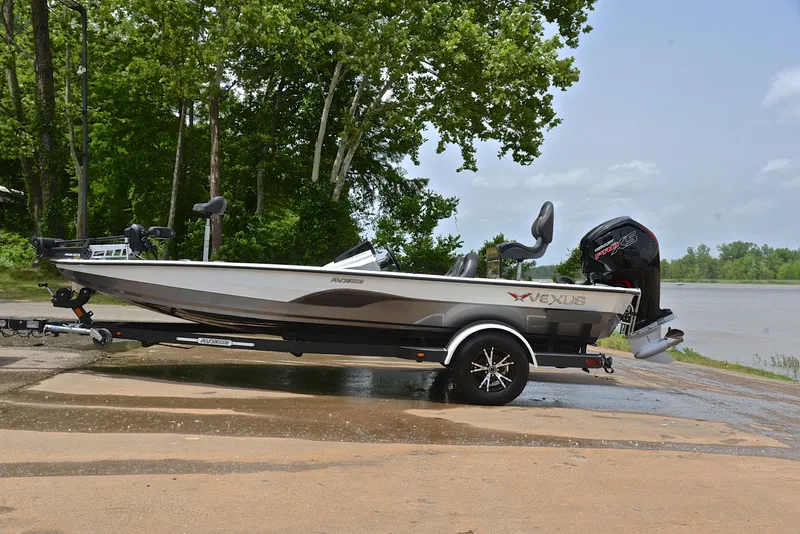 Slide: The Image of 2020 Vexus AVX1880 boat on trailer by a lake, surrounded by trees. - 11