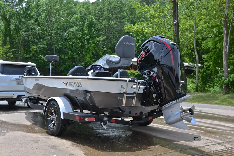 Slide: The Image of 2020 Vexus AVX1880 boat on trailer, parked outdoors near trees. - 12
