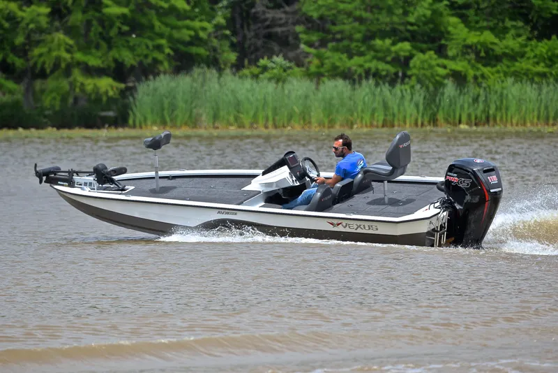 Slide: The Image of 2020 Vexus AVX1880 boat cruising on a lake with lush greenery in the background. - 6