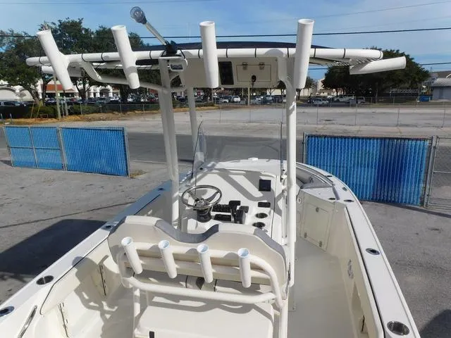 Slide: The Image of 2024 Stingray 216CC boat with T-top and rod holders, parked in a lot. - 10