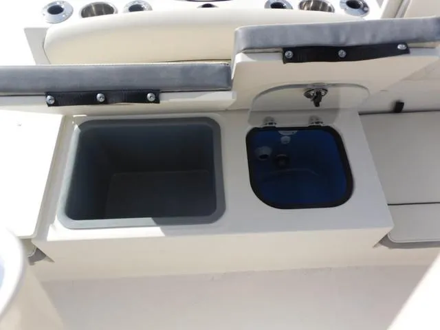 Slide: The Image of 2024 Stingray 216CC boat interior with storage compartments and cup holders. - 13