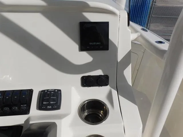 Slide: The Image of 2024 Stingray 216CC boat dashboard with Suzuki display and cup holder. - 18