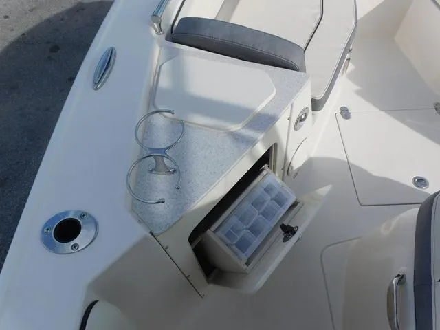 Slide: The Image of 2024 Stingray 216CC boat interior with storage compartment and cup holders. - 24